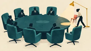 A person brings a small coral chair to a round table surrounded by large teal chairs.