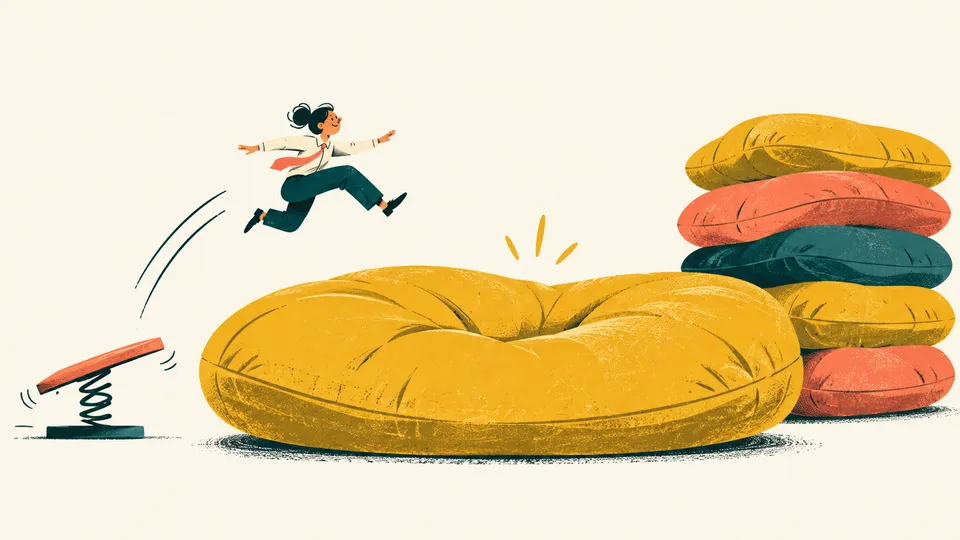 An office worker makes a practice jump onto an enormous yellow cushion.